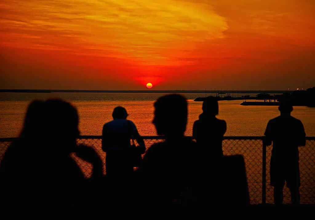 People watch the sunset over Port Darwin from Bicentennial Park on October 6, 2013 in Darwin, Australia. (Scott Barbour/Getty Images)