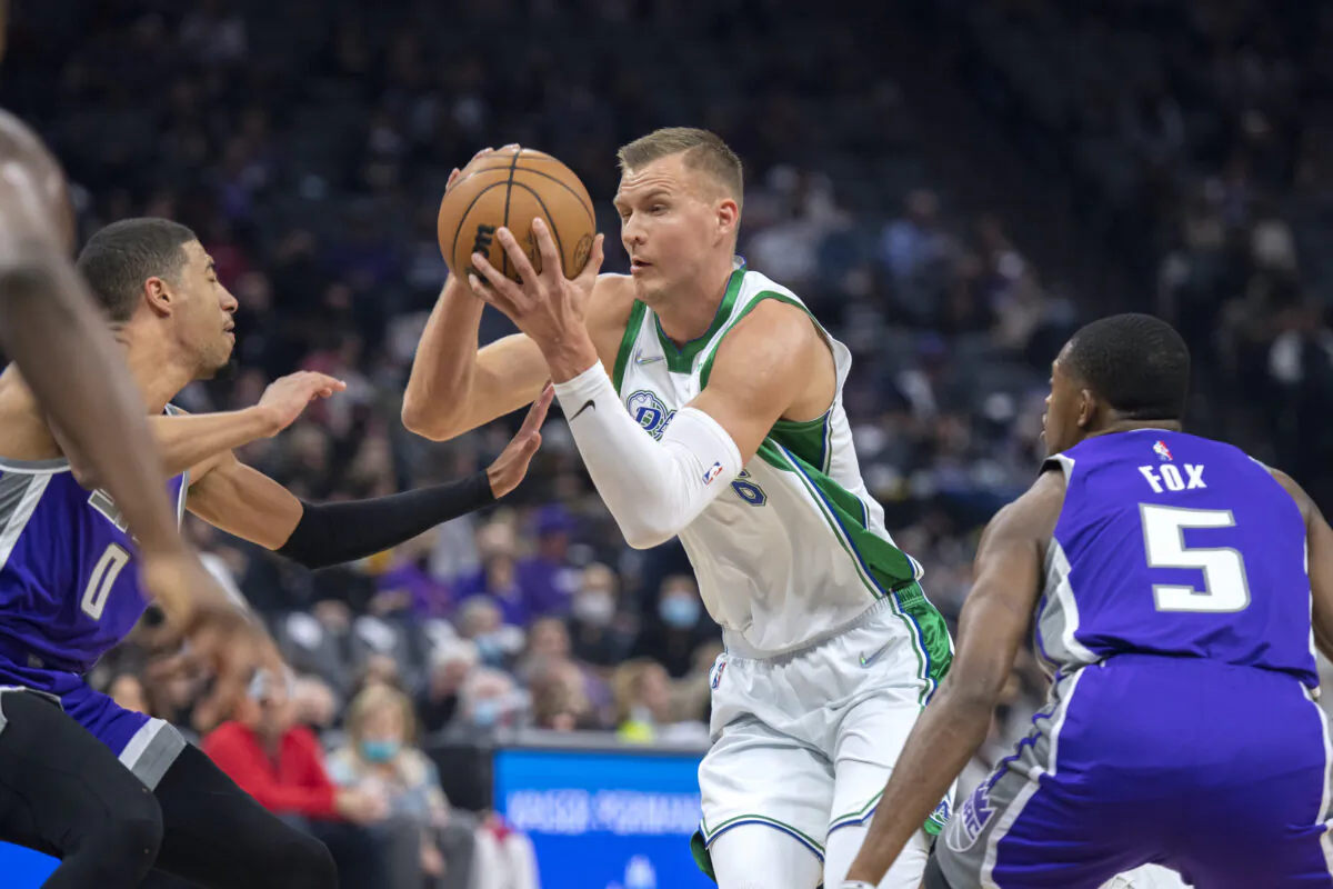 Dallas Mavericks center Kristaps Porzingis (6) drives between Sacramento Kings guard De'Aaron Fox (5) and guard Tyrese Haliburton (0) in the first quarter of an NBA basketball game in Sacramento, Calif., on Dec. 
29, 2021. (José Luis Villegas/AP Photo)