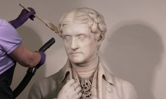A worker cleans a statue of President Thomas Jefferson inside the Capitol on Aug. 4, 2021. (Kevin Dietsch/Getty Images)