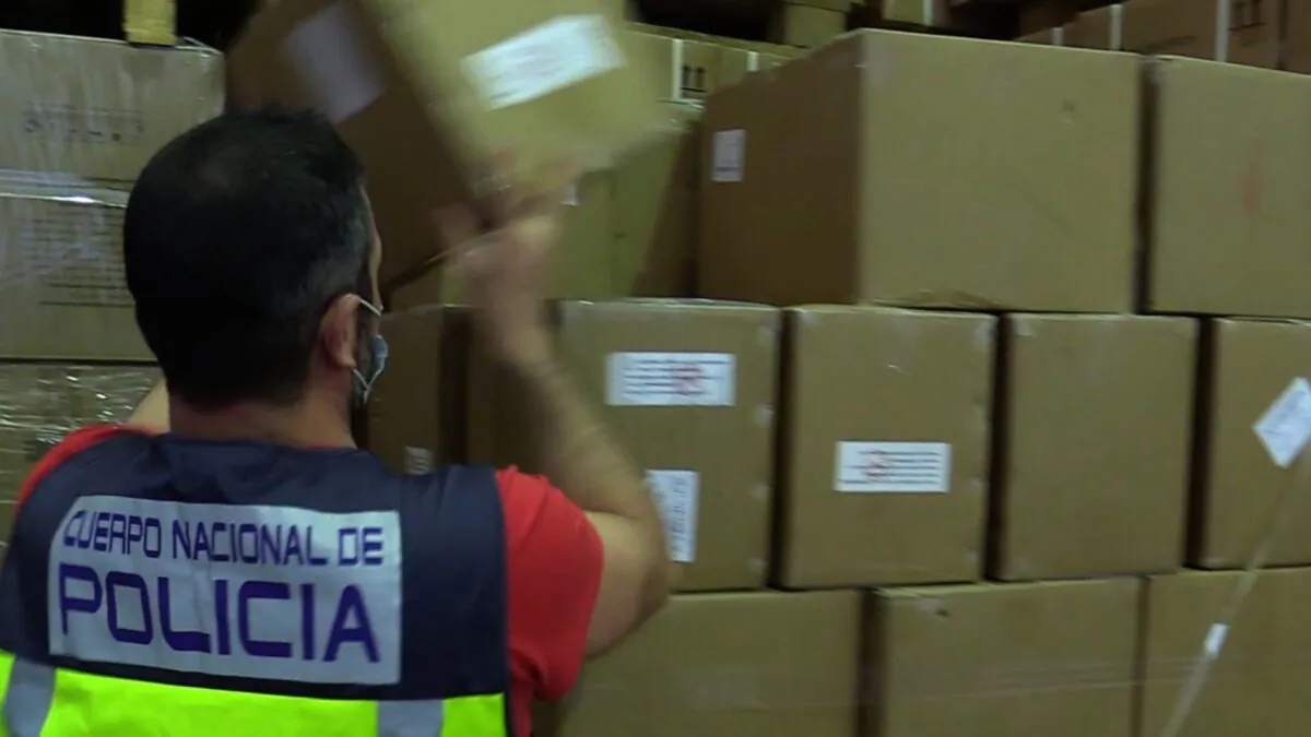 An agent from the Spanish National Police seizes a pallet with COVID-19 antigen tests after an inspection appears police to believe the tests fail to comply with specific protocols set by the government. (Courtesy of Spanish National Police)