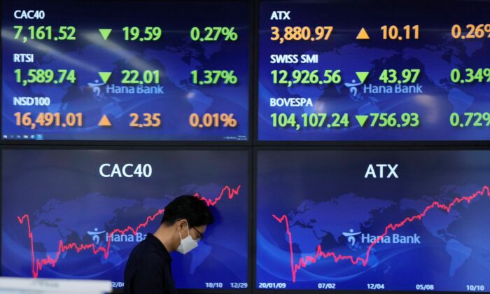 A currency trader walks by screens at a foreign exchange dealing room in Seoul, South Korea, on Dec. 30, 2021. (Lee Jin-man/AP Photo)