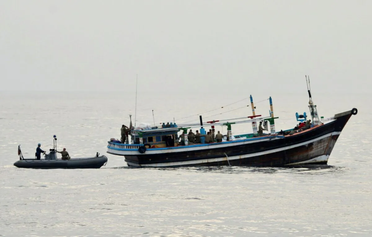 U.S. service members from coastal patrol ship USS Tempest (PC 2) and USS Typhoon (PC 5) approach a stateless dhow vessel carrying illicit drugs while transiting international waters in the Arabian Sea, on Dec. 27, 2021. (U.S. Navy photo via AP)