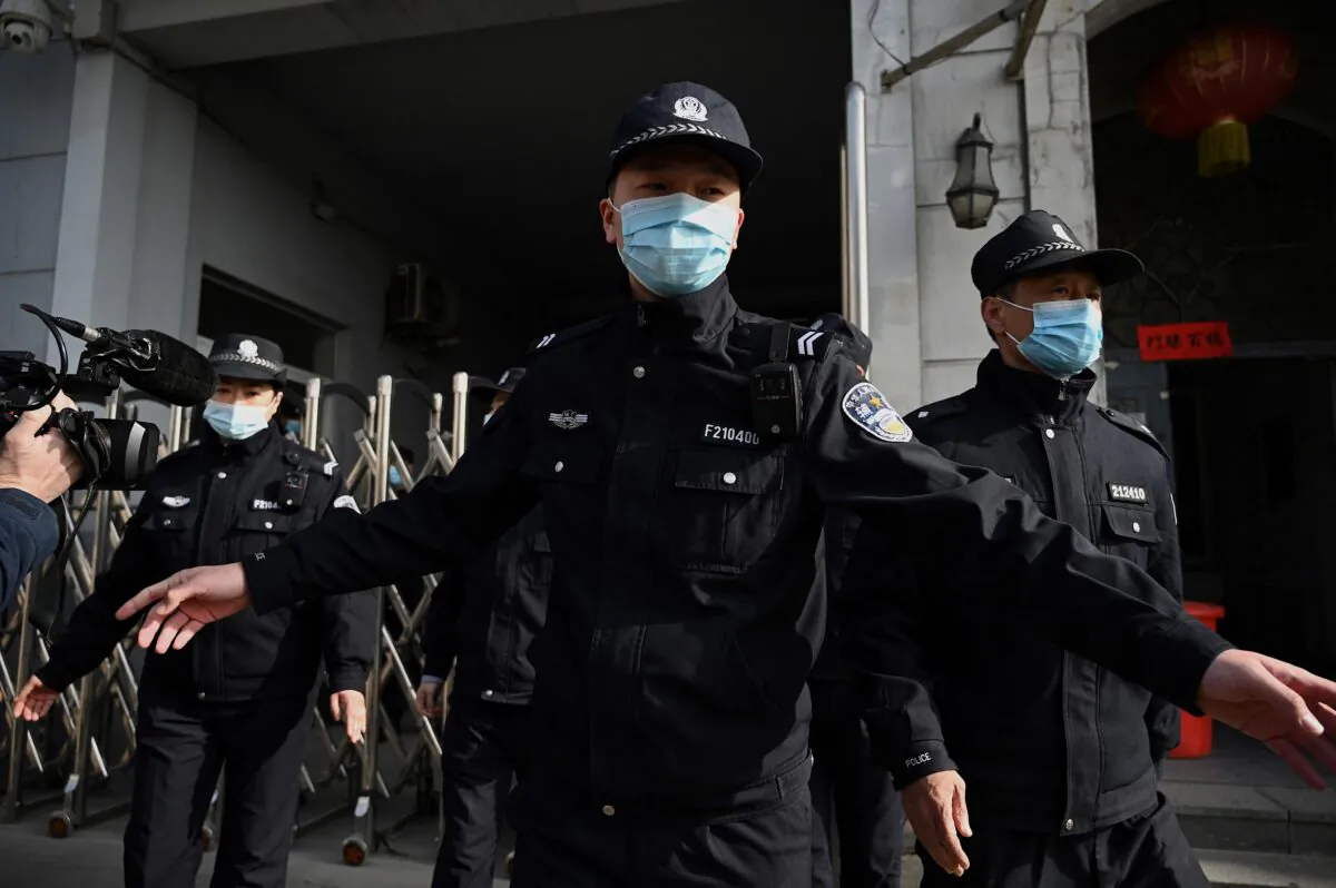 Policemen secure a side entrance following the arrival of police vehicles at the Dandong Intermediate People's Court in China's northeast Liaoning province on March 19, 2021. (Noel Celis/AFP via Getty Images)