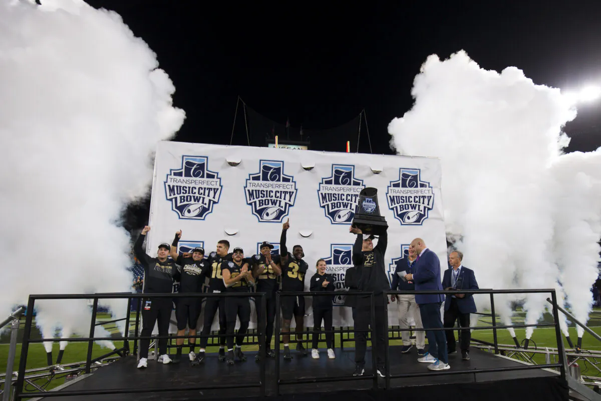 Head coach Jeff Brohm of the Purdue Boilermakers hoists the TransPerfect Music City Bowl trophy after defeating the Tennessee Volunteers at Nissan Stadium in Nashville, on Dec. 30, 2021. (Brett Carlsen/Getty Images) 