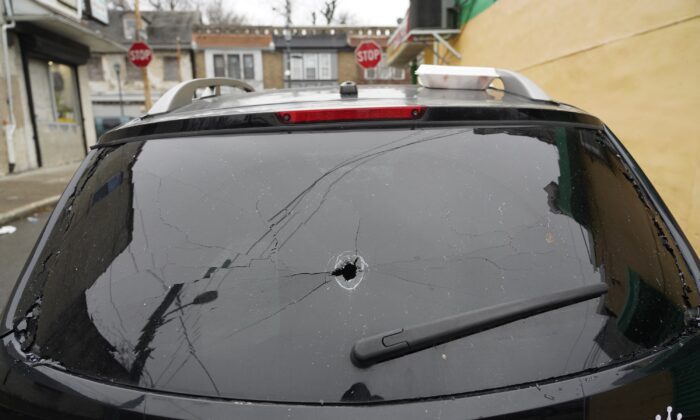 Parked vehicles are seen with bullet holes in the rear window, in Philadelphia on  Dec. 31, 2021. (Michael Perez/AP Photo)