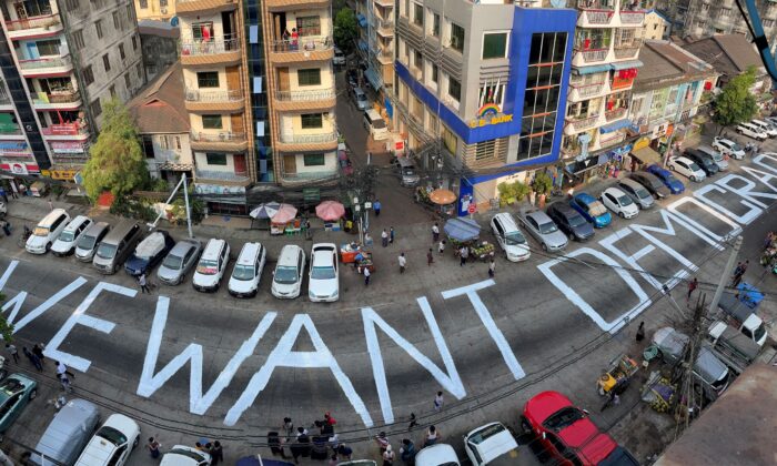 A slogan is written on a street as a protest after the coup in Yangon, Burma, on Feb. 21, 2021. (Stringer/Reuters)