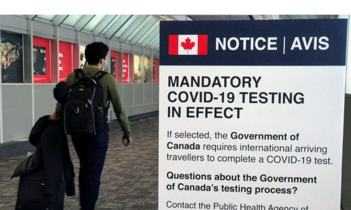 A traveler walks past a "Mandatory COVID-19 Testing" sign at Pearson International Airport during the coronavirus disease (COVID-19) pandemic of Toronto, Ontario, Canada, December 18, 2021. (Reuters/Carlo Allegri)