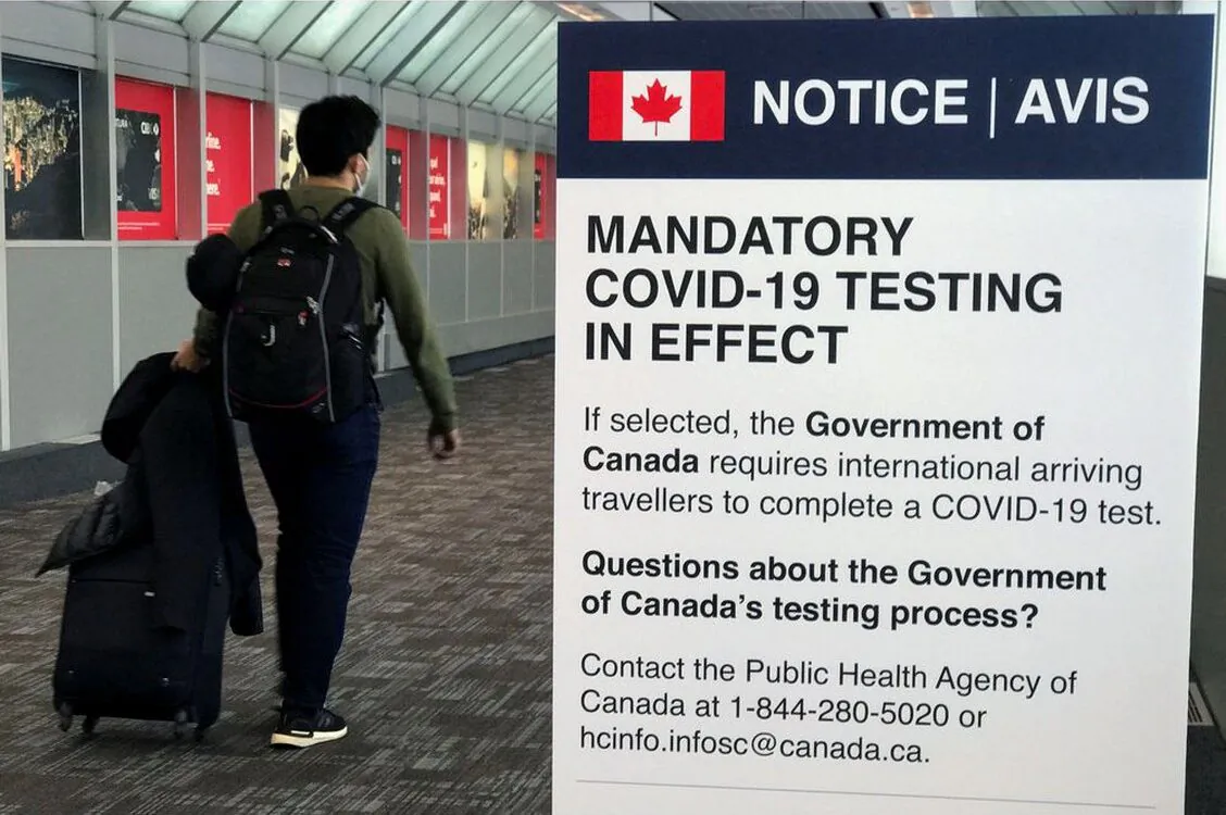 A traveler walks past a "Mandatory COVID-19 Testing" sign at Pearson International Airport during the coronavirus disease (COVID-19) pandemic of Toronto, Ontario, Canada, December 18, 2021. (Reuters/Carlo Allegri)