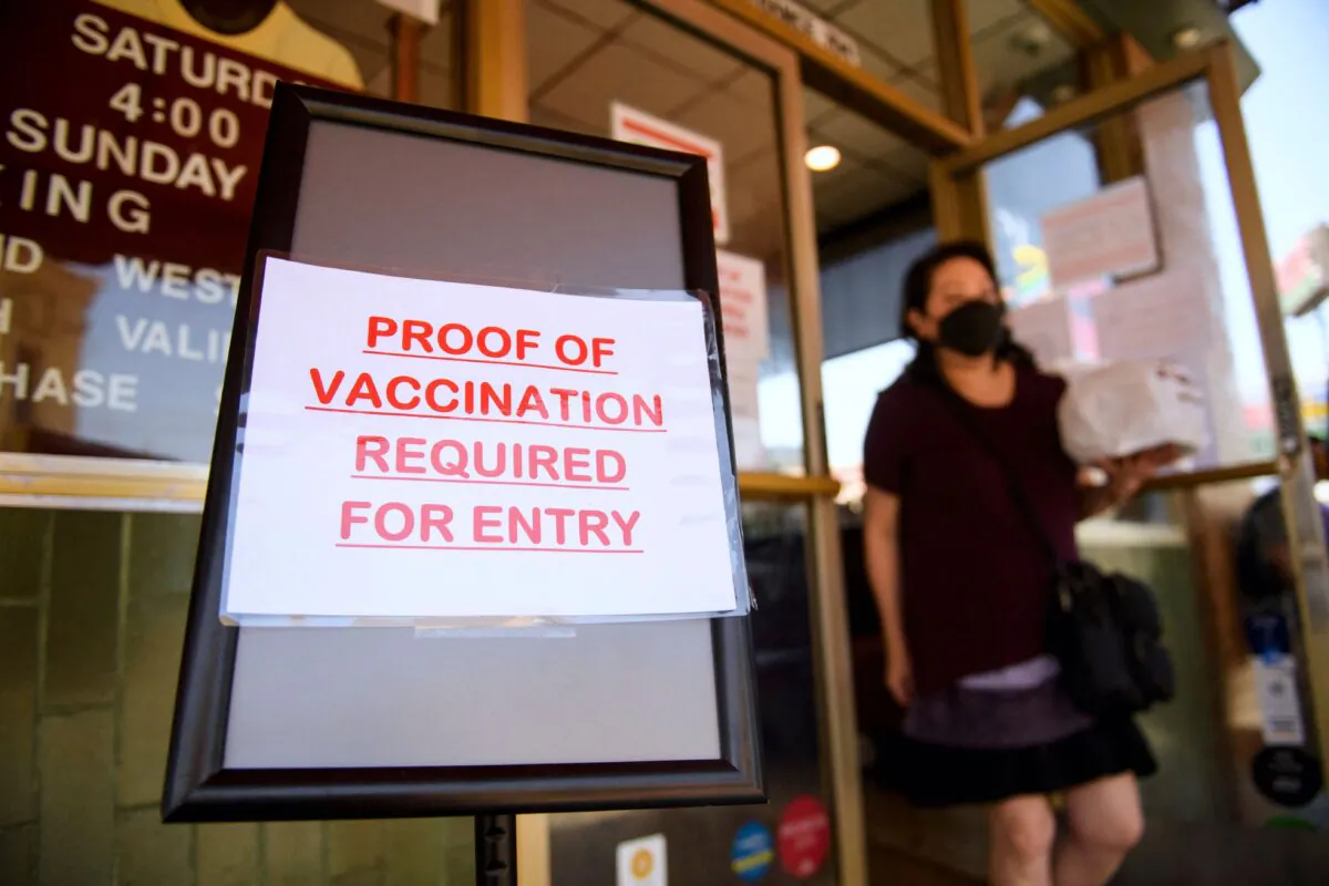A sign stating proof of a Covid-19 vaccination is required is displayed outside of Langer's Deli in Los Angeles, California on Aug. 7, 2021. (Patrick T. Fallon/AFP via Getty Images)