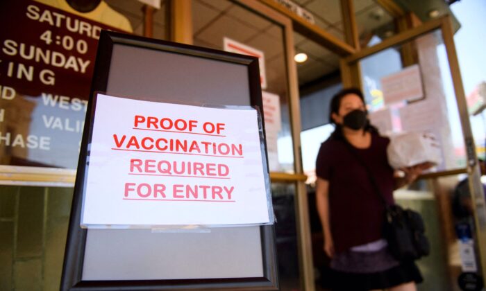 A sign stating proof of a Covid-19 vaccination is required is displayed outside of Langer's Deli in Los Angeles, California on Aug. 7, 2021. (PATRICK T. FALLON/AFP via Getty Images)