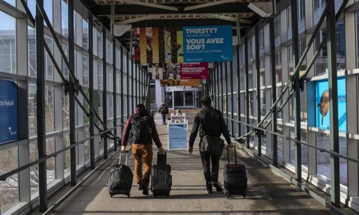 Travelers carry luggage to their flights at the Edmonton International airpot in Edmonton Alta., Dec. 2, 2021. (The Canadian Press/Jason Franson)