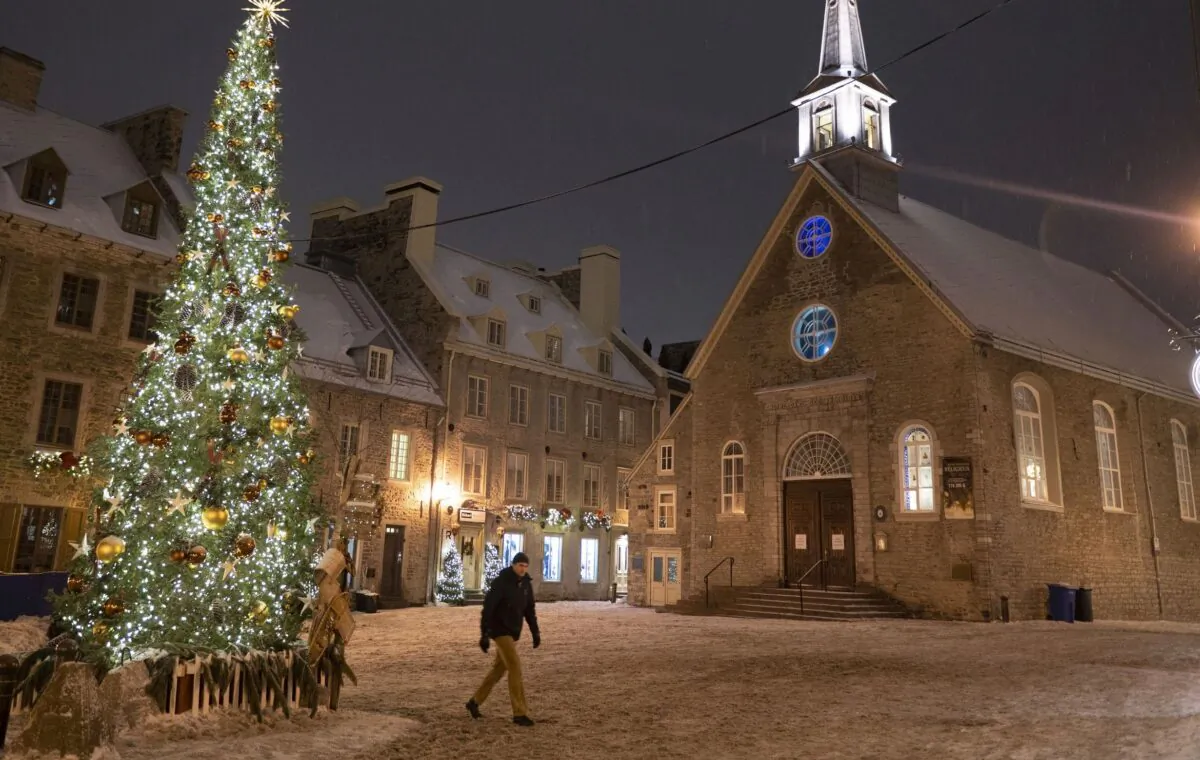 A man walks through a deserted Place Royale in Quebec City on the evening of Dec. 31, 2021, shortly before the provincial government’s nightly curfew came into effect. (The Canadian Press/Jacques Boissinot)