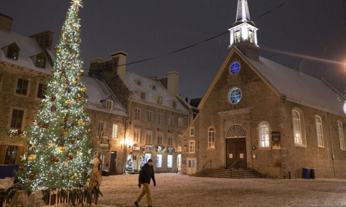 A man walks through a deserted Place Royale in Quebec City on the evening of Dec. 31, 2021, shortly before the provincial government’s nightly curfew came into effect. (The Canadian Press/Jacques Boissinot)