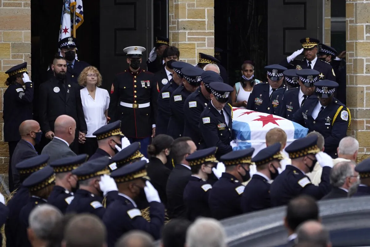 Elizabeth French, in white, and her son Andrew (L) follow the casket of her daughter, Chicago police officer Ella French, after a funeral service at the St. Rita of Cascia Shrine Chapel, in Chicago, Ill., on Aug. 19, 2021. (Charles Rex Arbogast/AP Photo)