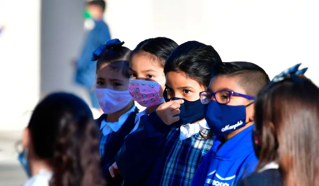 A student adjusts her facemask at St. Joseph Catholic School in La Puente, Calif., on Nov. 16, 2020, where pre-kindergarten to second-grade students in need of special services returned to the classroom today for in-person instruction. (Frederic J. Brown/AFP via Getty Images)