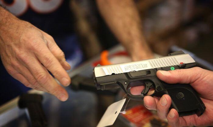 A customer shops for a pistol at Freddie Bear Sports sporting goods store in Tinley Park, Ill., on Dec. 17, 2012. (Scott Olson/Getty Images)