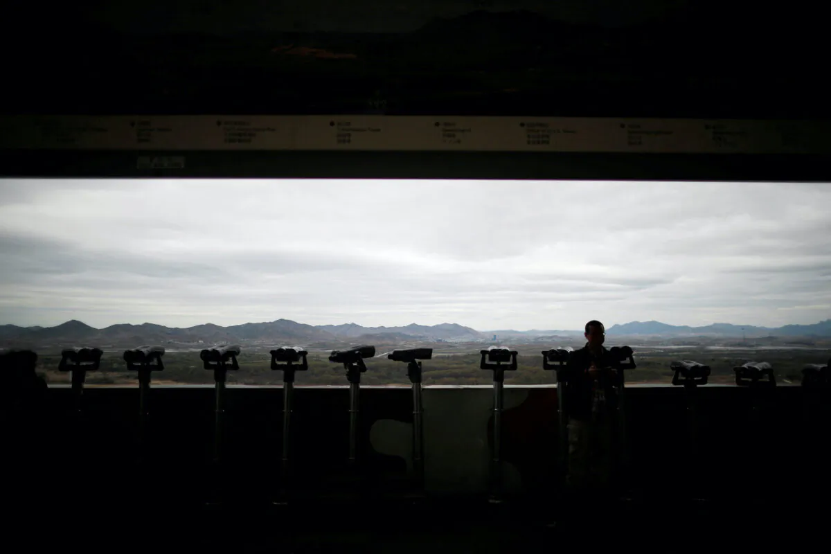 A man stands near binoculars as he tries to see North Korea's propaganda village of Gijungdong at the Dora observatory near the demilitarized zone separating the two Koreas, in Paju, South Korea, on April 24, 2018. (Kim Hong-Ji/Reuters)