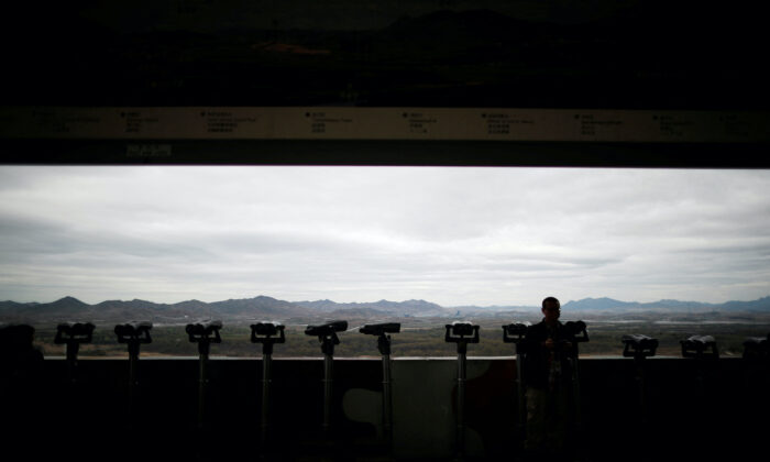 A man stands near binoculars as he tries to see North Korea's propaganda village of Gijungdong at the Dora observatory near the demilitarized zone separating the two Koreas, in Paju, South Korea, on April 24, 2018. (Kim Hong-Ji/Reuters)
