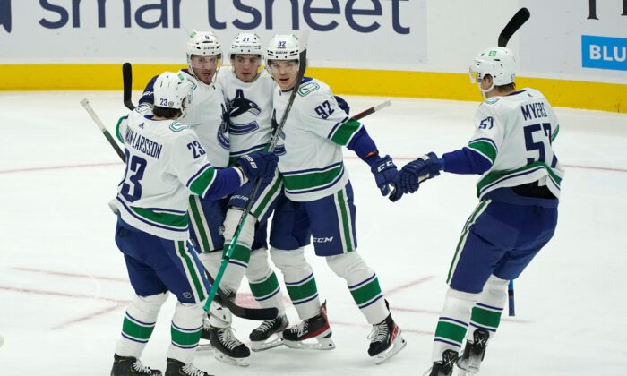 Vancouver Canucks right wing Vasily Podkolzin, second from right, is greeted by teammates after he scored a goal against the Seattle Kraken during the first period of an NHL hockey game in Seattle, on Jan. 1, 2022. (Ted S. Warren/AP Photo)