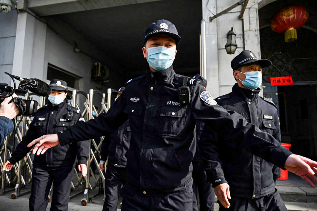 Policemen secure a side entrance following the arrival of police vehicles at the Dandong Intermediate People's Court in China's northeast Liaoning province on March 19, 2021. (Noel Celis/AFP via Getty Images)