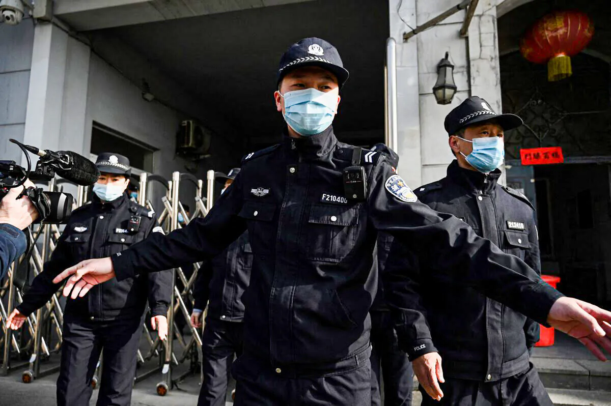 Policemen secure a side entrance following the arrival of police vehicles at the Dandong Intermediate People's Court in China's northeast Liaoning province on March 19, 2021. (Noel Celis/AFP via Getty Images)