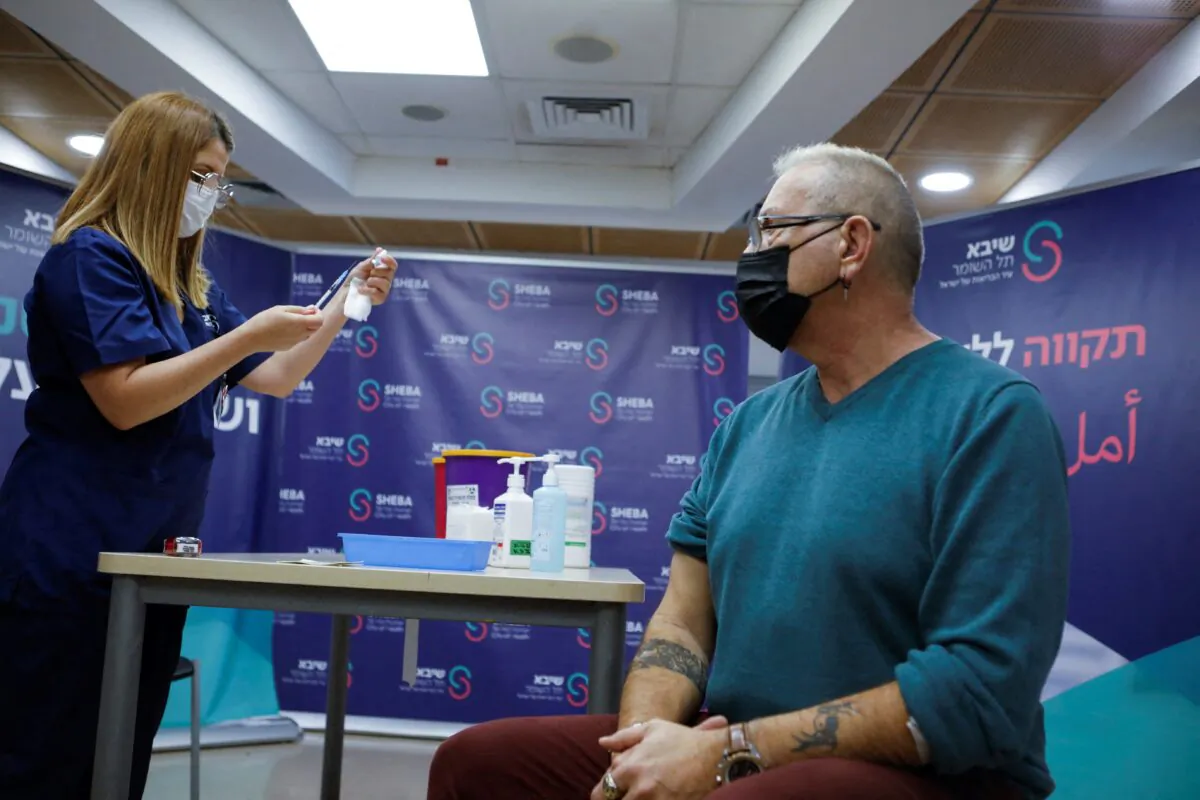 A medical worker prepares to give 62-year-old Moshe Geva Rosso a fourth dose of the COVID-19 vaccine, at Sheba Medical Center in Ramat Gan, Israel, on Dec. 31, 2021. (Nir Elias/Reuters)