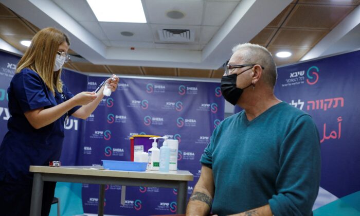 A medical worker prepares to give 62-year-old Moshe Geva Rosso a fourth dose of the COVID-19 vaccine, at Sheba Medical Center in Ramat Gan, Israel, on Dec. 31, 2021. (Nir Elias/Reuters)