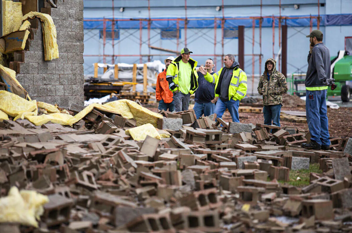 Utility workers and city crews survey and help clear debris at Thornton Furniture on Cave Mill Road in Bowling Green, Ky.,, following the devastating tornadoes that tore through town on Dec. 11, 2021. (Grace Ramey/Bowling Green Daily News via AP)