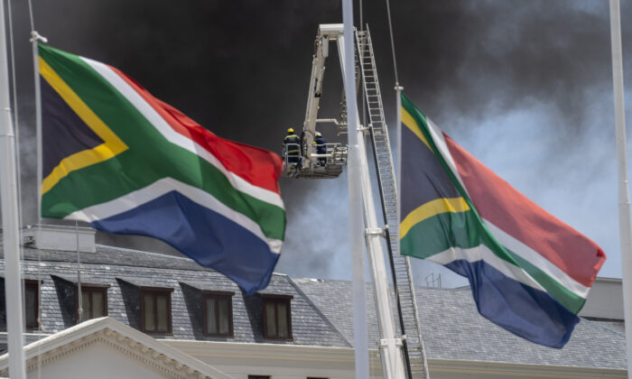 Firemen spray water on flames erupting from a building at South Africa's Parliament in Cape Town on Jan. 2, 2022. (Jerome Delay/AP Photo)
