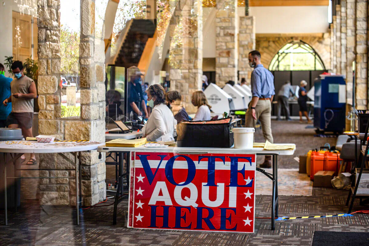 Poll workers help voters inside a polling location in Austin, Texas, on Oct. 13, 2020. (Sergio Flores/Getty Images)
