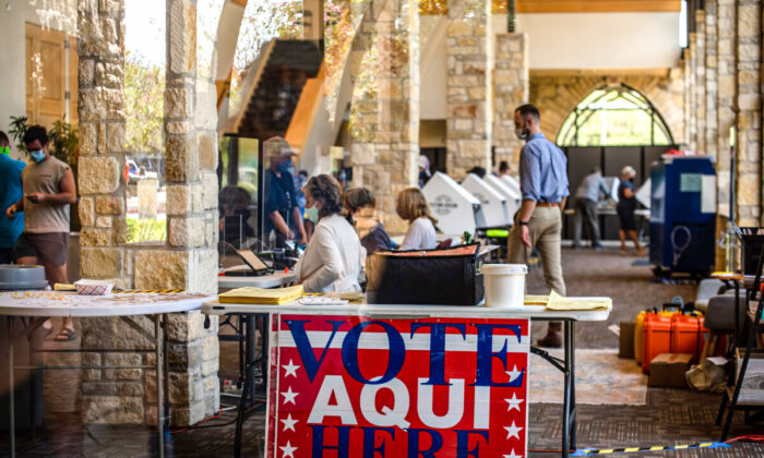 Poll workers help voters inside a polling location in Austin, Texas, on Oct. 13, 2020. (Sergio Flores/Getty Images)