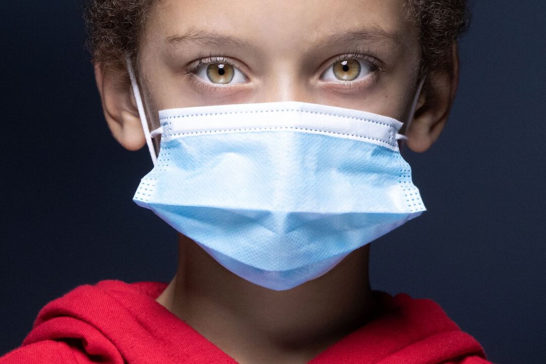 A 6-year-old boy poses with a mask in Paris, France, on Nov. 8, 2020. (Joel Saget/AFP via Getty Images)