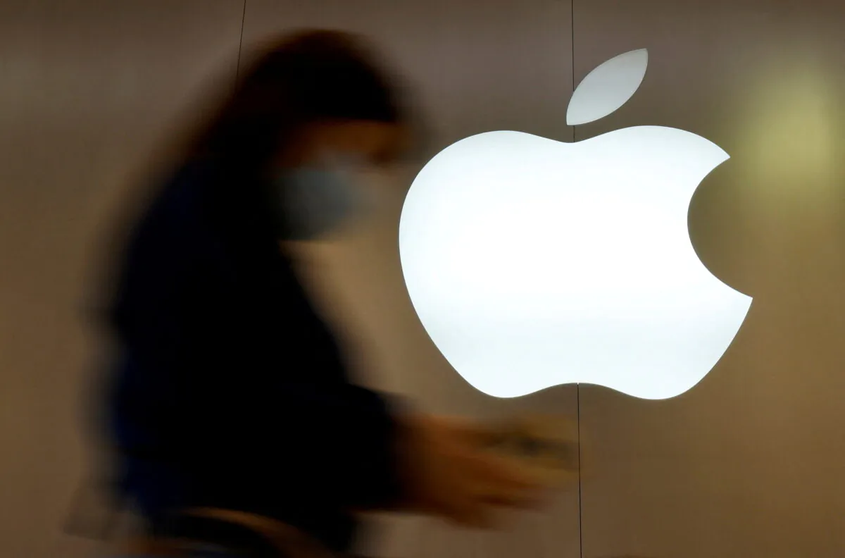 A woman walks past an Apple logo in front of an Apple store in Saint-Herblain near Nantes, France, on Sept. 16, 2021. (Stephane Mahe/Reuters)