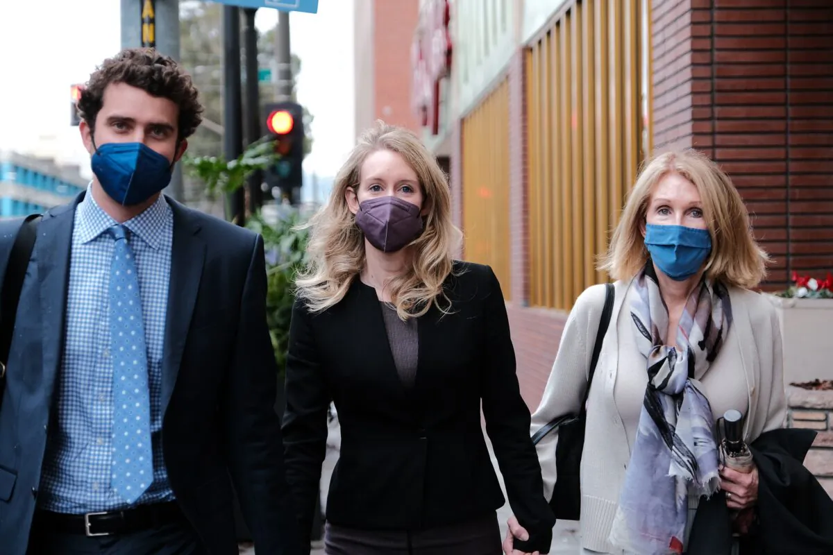 Billy Evans walks with his partner Elizabeth Holmes, and her mother Noel Holmes, as they leave the Robert F. Peckham Federal Building in San Jose, Calif., on Dec. 23, 2021. (David Odisho/Getty Images)