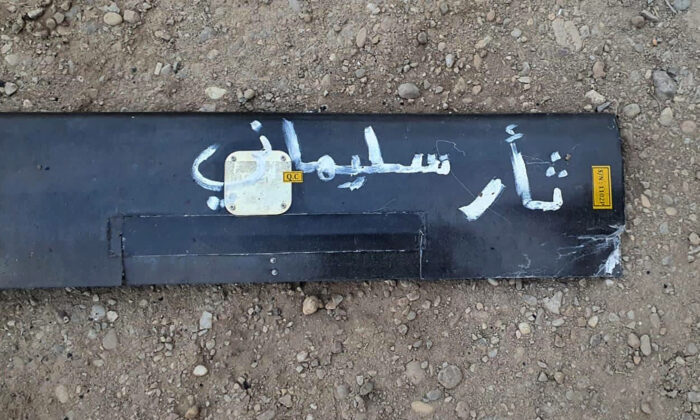 A part from the wreckage of a drone with Arabic that reads, "Soleimani's revenge" lies on the ground at Baghdad airport, Iraq, on Jan. 3, 2022. (International Coalition via AP)