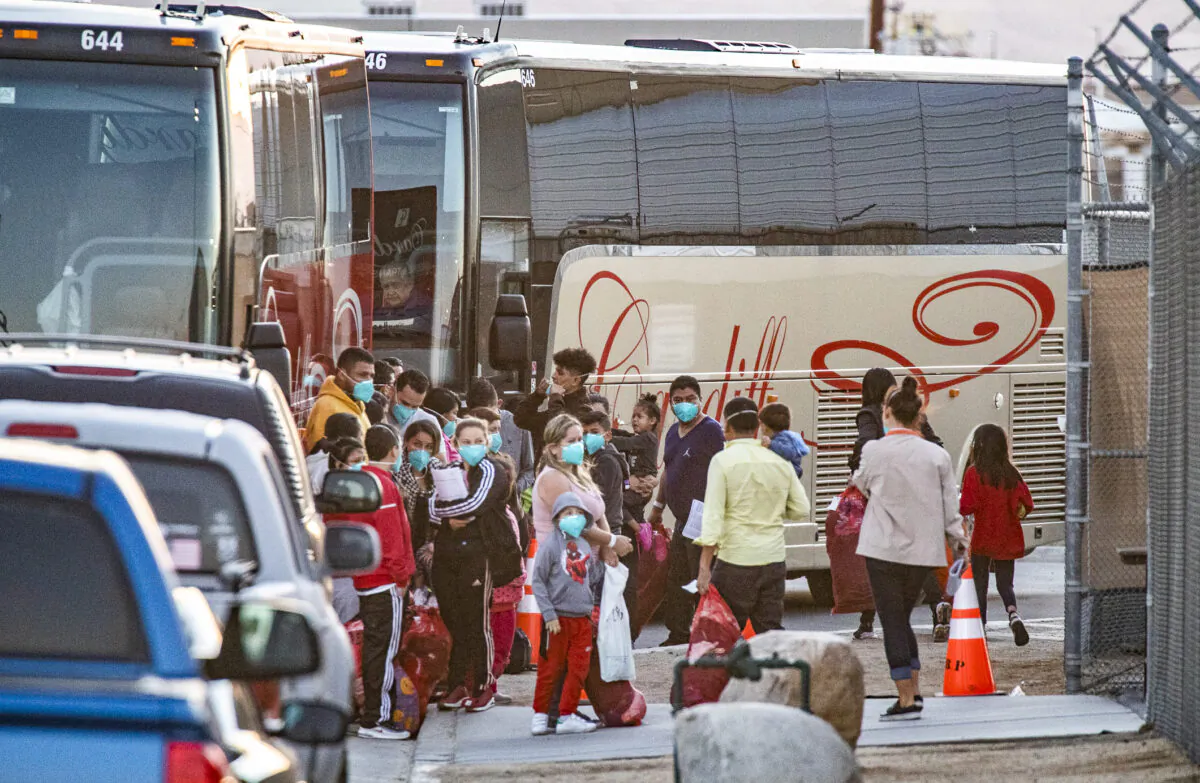 Immigrants are moved from the custody of Department of Homeland Security officials and released onto charter buses to be transferred into local motels in Indio, Calif., on Oct. 18, 2021. (John Fredricks/The Epoch Times)