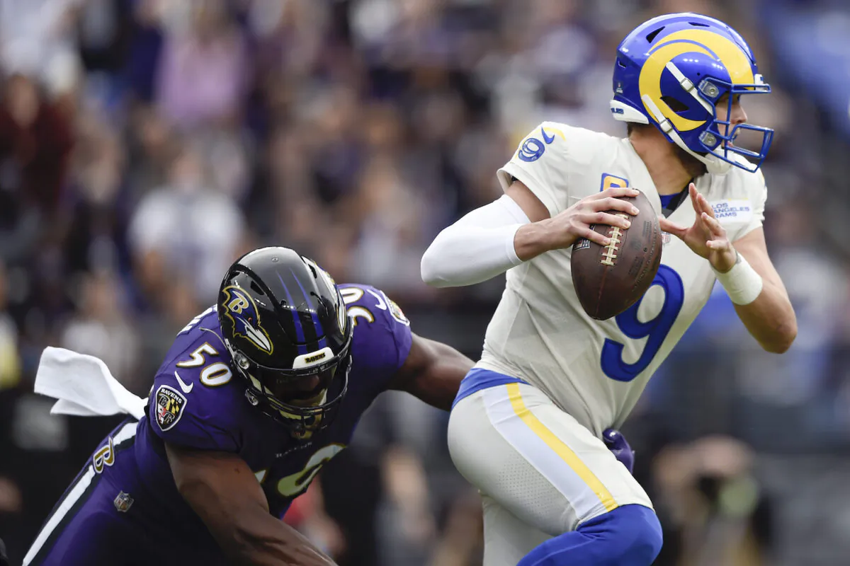 Los Angeles Rams quarterback Matthew Stafford (9) dodges a sack attempt by Baltimore Ravens outside linebacker Justin Houston (50) during the first half of an NFL football game in Baltimore on Jan. 2, 2022. (AP Photo/Gail Burton)