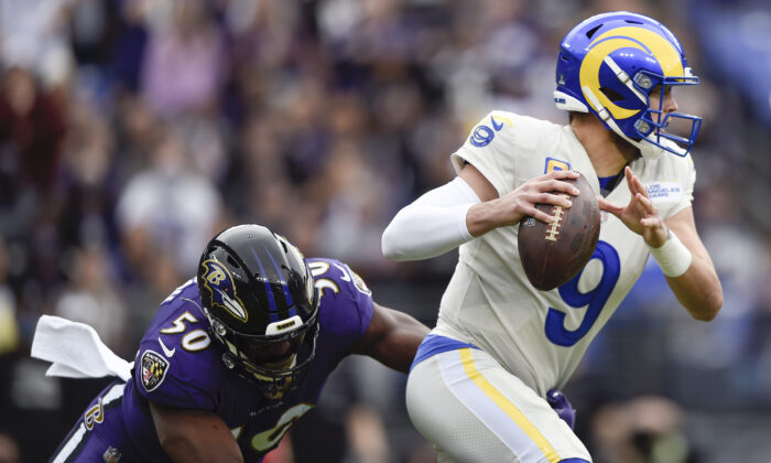 Los Angeles Rams quarterback Matthew Stafford (9) dodges a sack attempt by Baltimore Ravens outside linebacker Justin Houston (50) during the first half of an NFL football game in Baltimore on Jan. 2, 2022. (AP Photo/Gail Burton)