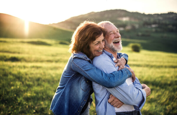 Side,View,Of,Senior,Couple,Hugging,Outside,In,Spring,Nature