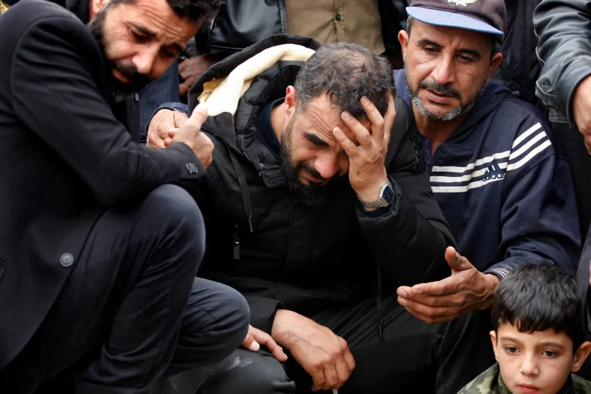Syrian Maher al-Abdallah (C) mourns his wife and three children who died in their sleep after inhaling toxic fumes from burning coal to heat their room, during their funeral procession in Al-Wasta village near the southern port city of Sidon, Lebanon, on Jan. 2, 2022. (Mohammed Zaatari/AP Photo)