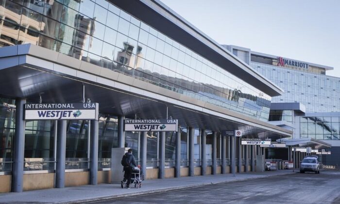 A lone traveler enters the Calgary Airport in Calgary, Alta., Feb. 22, 2021. (The Canadian Press/Jeff McIntosh)