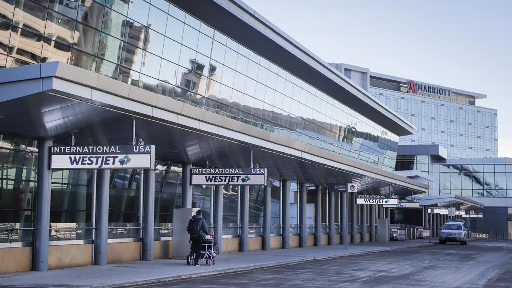 A lone traveler enters the Calgary Airport in Calgary, Alta., Feb. 22, 2021. (The Canadian Press/Jeff McIntosh)