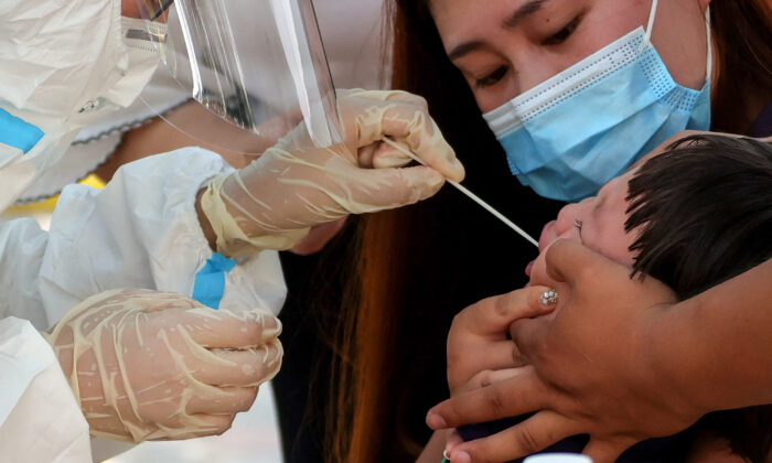 A child receives a swab for a nucleic acid test for COVID-19 in Zhengzhou, Henan Province on July 31, 2021. (-/AFP via Getty Images)