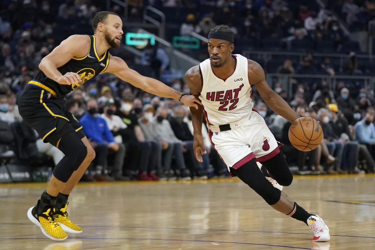 Miami Heat forward Jimmy Butler (22) drives to the basket against Golden State Warriors guard Stephen Curry, during an NBA game in San Francisco, on Jan. 3, 2022. (Jeff Chiu/AP Photo)