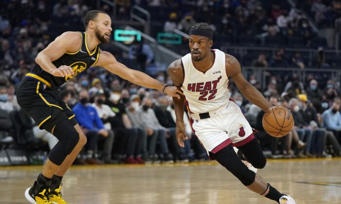 Miami Heat forward Jimmy Butler (22) drives to the basket against Golden State Warriors guard Stephen Curry, during an NBA game in San Francisco, on Jan. 3, 2022. (Jeff Chiu/AP Photo)