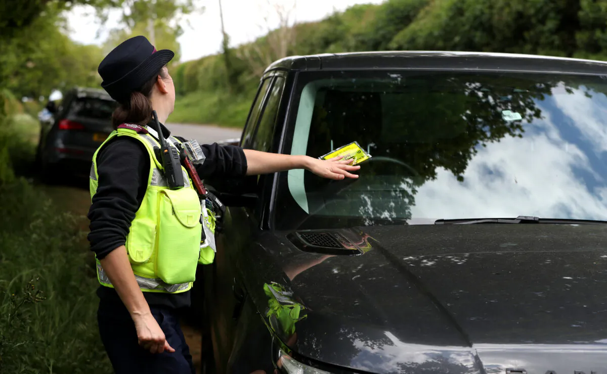 A traffic warden issues a parking ticket to an illegally parked car near Sywell Country Park in Northampton, United Kingdom on May 16, 2020  (David Rogers/Getty Images)