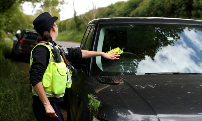 A traffic warden issues a parking ticket to an illegally parked car near Sywell Country Park in Northampton, United Kingdom on May 16, 2020  (David Rogers/Getty Images)