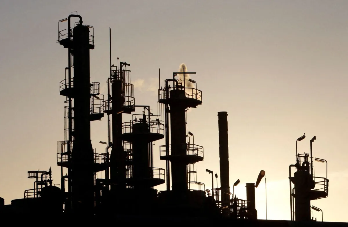 Towers and smokestacks are silhouetted at an oil refinery in Melbourne, on June 21, 2010. (Mick Tsikas/Reuters)