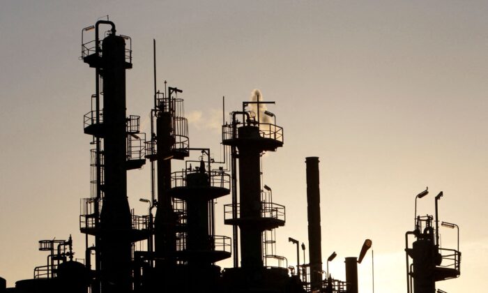 Towers and smokestacks are silhouetted at an oil refinery in Melbourne, on June 21, 2010. (Mick Tsikas/Reuters)