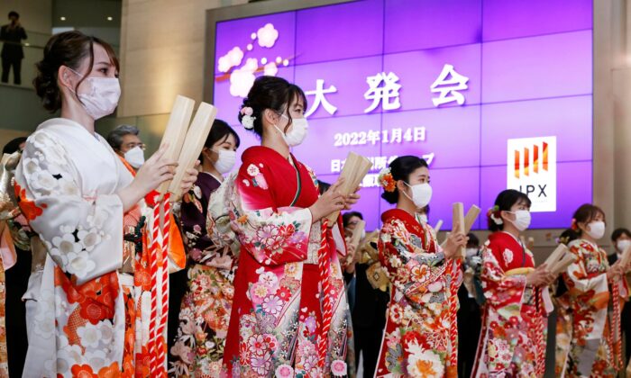 Workers attend a ceremony to mark the first trading day of the year at Osaka Exchange in Osaka, western Japan, on Jan. 4, 2022. (Kyodo News via AP)
